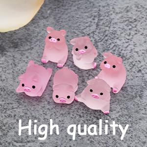 Six small pink silicone or rubber figures shaped like cartoon animals or characters. They have simple facial features and are placed on a gray textured surface.