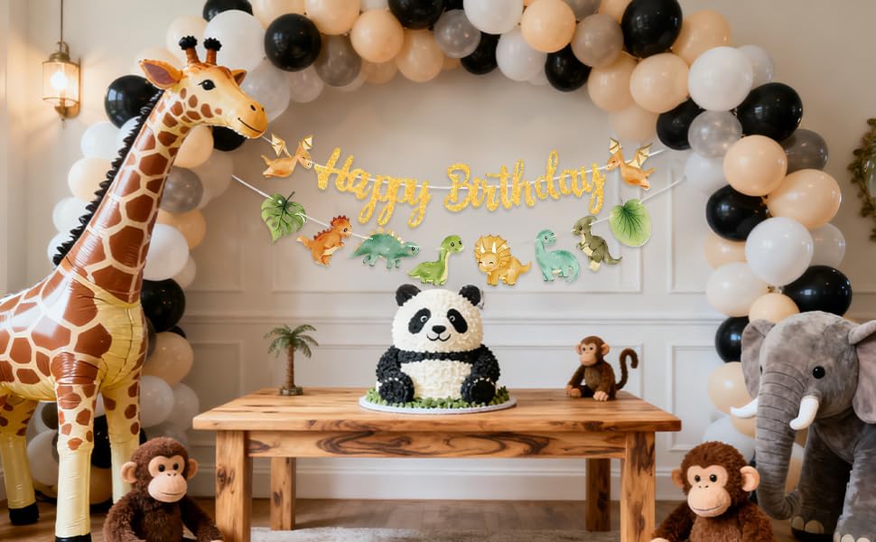 Text reads 'Happy Birthday'. Party decoration scene with stuffed animal toys including pandas, giraffes, and monkeys arranged under festive banner with balloons.