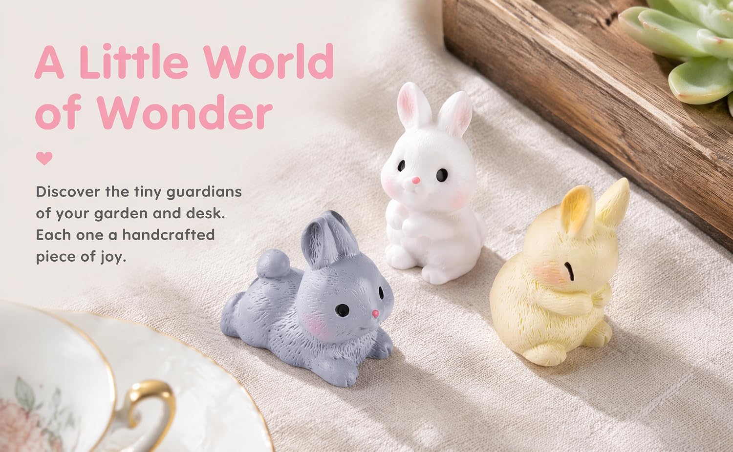 Text reads 'A Little World of Wonder' and 'Discover the tiny guardians of your garden and desk. A piece of you.' Three plush toy animals in white, purple, and yellow on wooden surface with decorative elements.